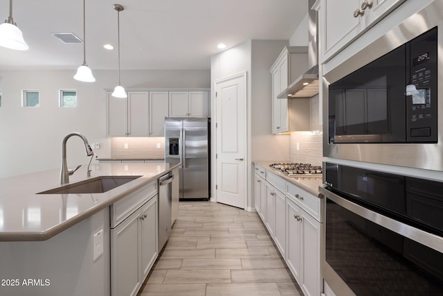 2644 S Dock St, Gilbert, AZ 85295 - kitchen featuring a sink, appliances with stainless steel finishes, decorative backsplash, and hanging light fixtures