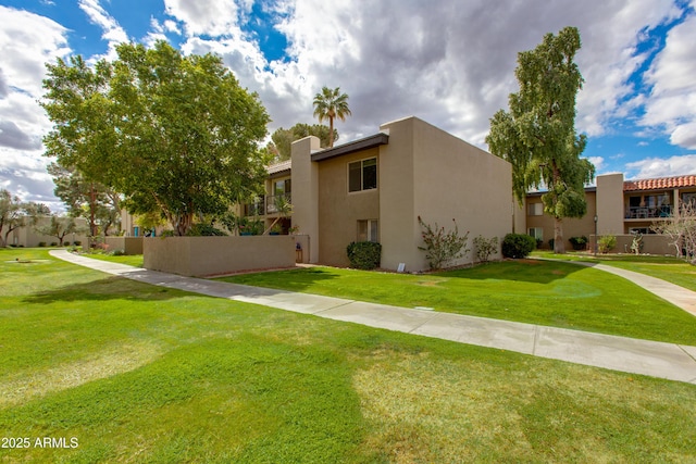 view of side of home with stucco siding and a lawn