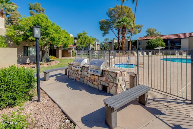 exterior space with a community pool, area for grilling, and fence