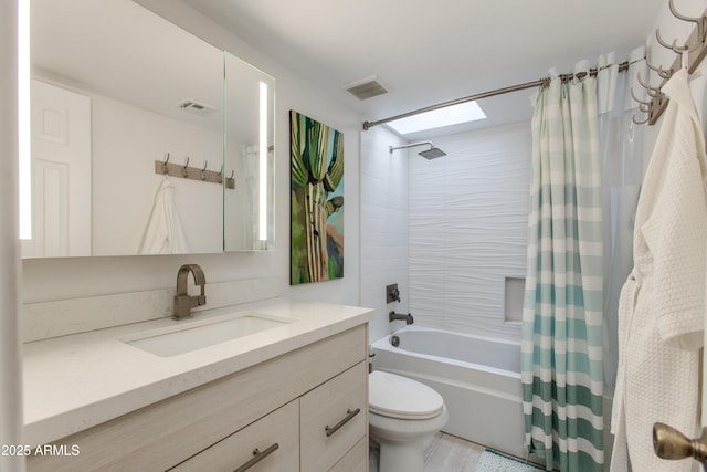 bathroom featuring visible vents, vanity, toilet, and shower / tub combo