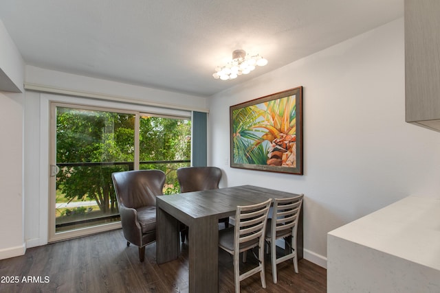 dining room featuring wood finished floors, baseboards, and a chandelier