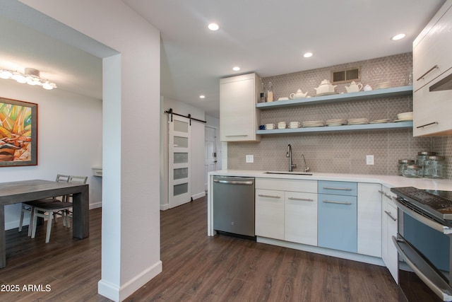 kitchen featuring visible vents, a sink, a barn door, appliances with stainless steel finishes, and light countertops