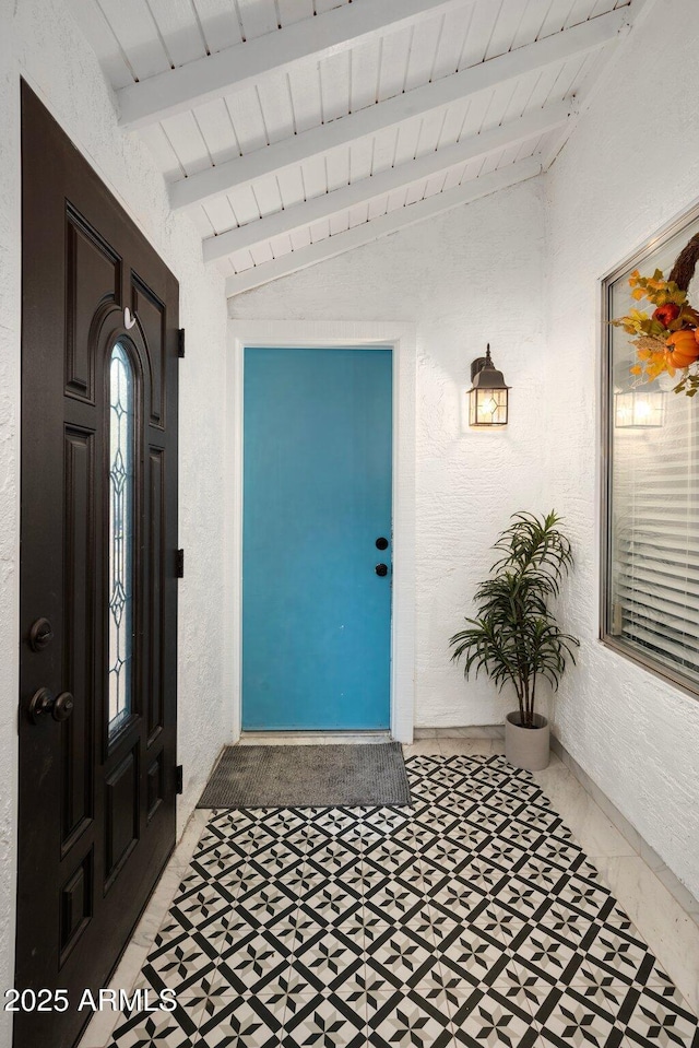 entryway with wooden ceiling and lofted ceiling with beams