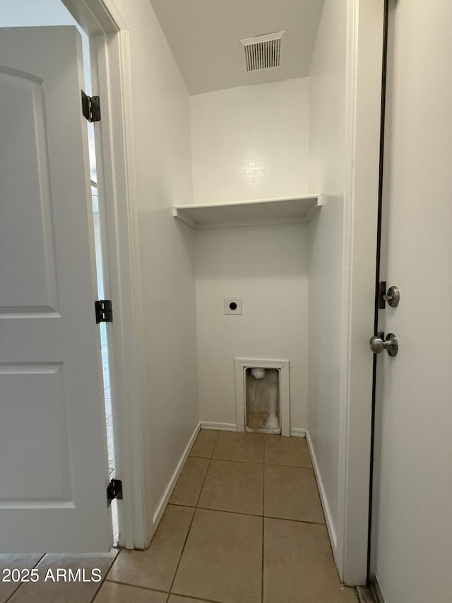 laundry area featuring laundry area, visible vents, baseboards, tile patterned floors, and electric dryer hookup