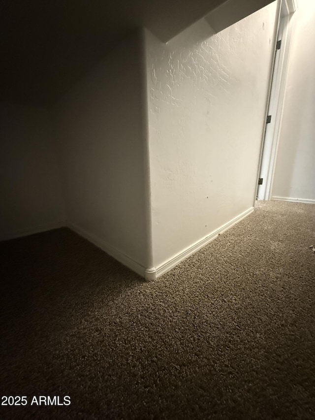 carpeted spare room with baseboards