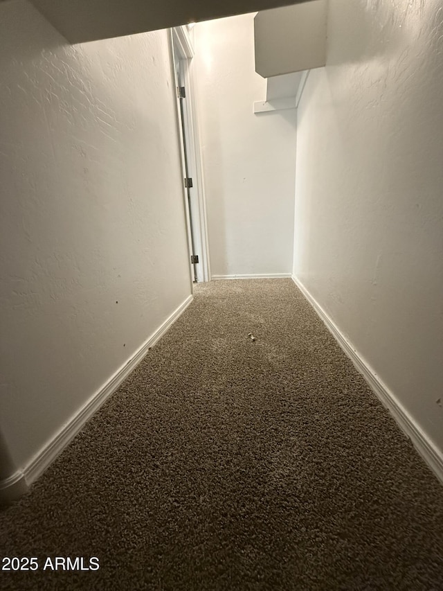 hallway with carpet flooring and baseboards