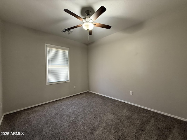 empty room with baseboards, visible vents, dark carpet, and a ceiling fan