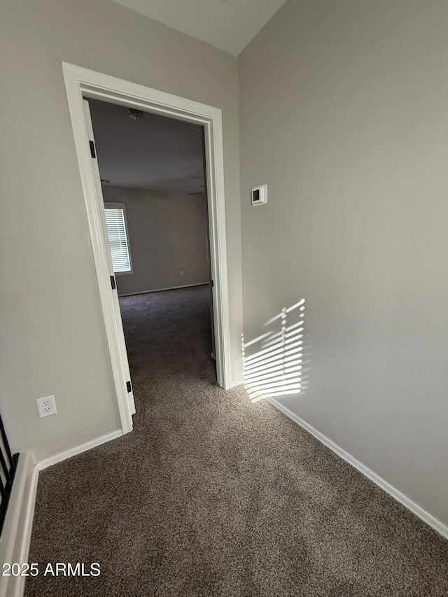 corridor featuring carpet flooring and baseboards