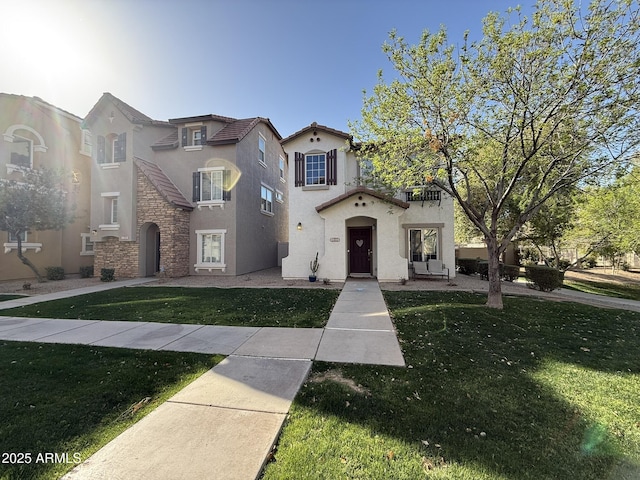 mediterranean / spanish home with a front lawn and stucco siding