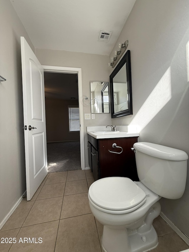 bathroom featuring visible vents, toilet, vanity, tile patterned flooring, and baseboards