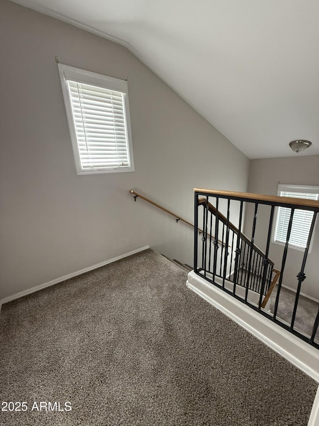 stairway featuring carpet, baseboards, and vaulted ceiling