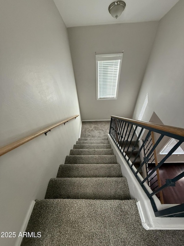 stairway featuring carpet floors and baseboards