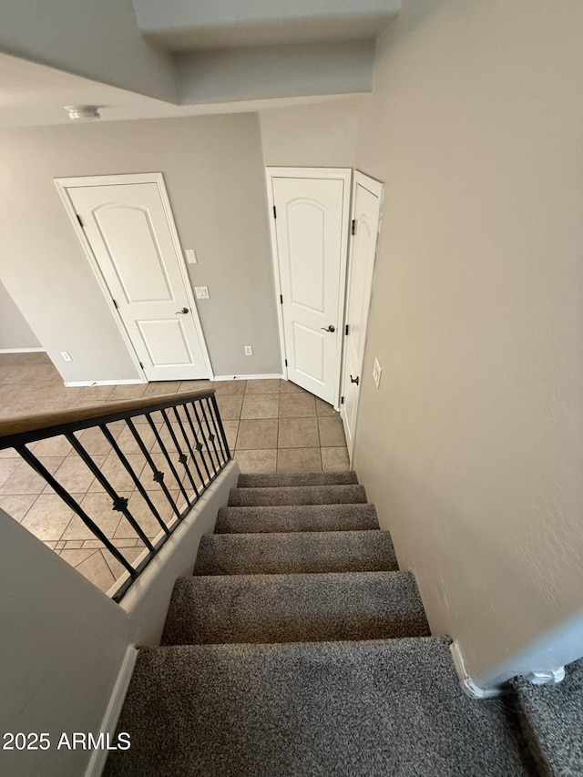 stairs featuring tile patterned flooring and baseboards