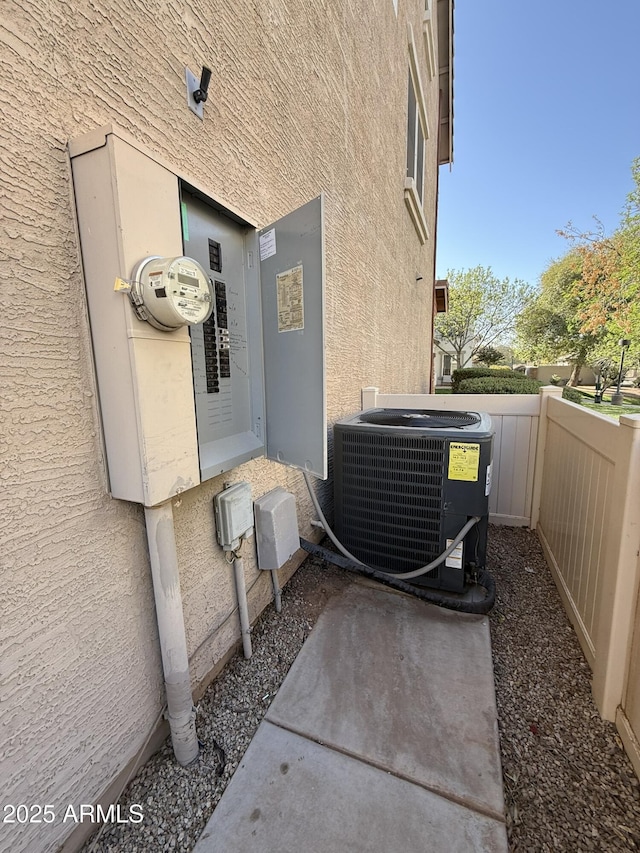 details featuring central AC, fence, and stucco siding