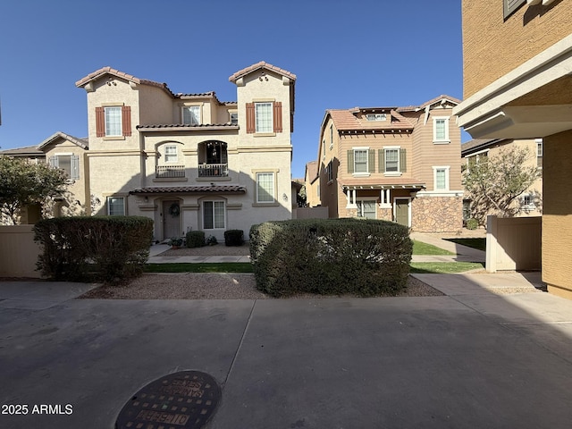 view of front of home featuring a balcony, stucco siding, and a tiled roof