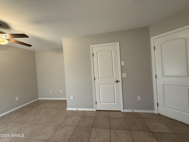 unfurnished room featuring tile patterned flooring, baseboards, and a ceiling fan