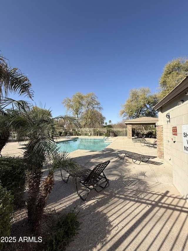 community pool featuring a patio and fence