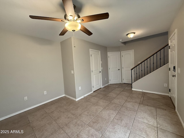 spare room with ceiling fan, stairs, baseboards, and light tile patterned flooring