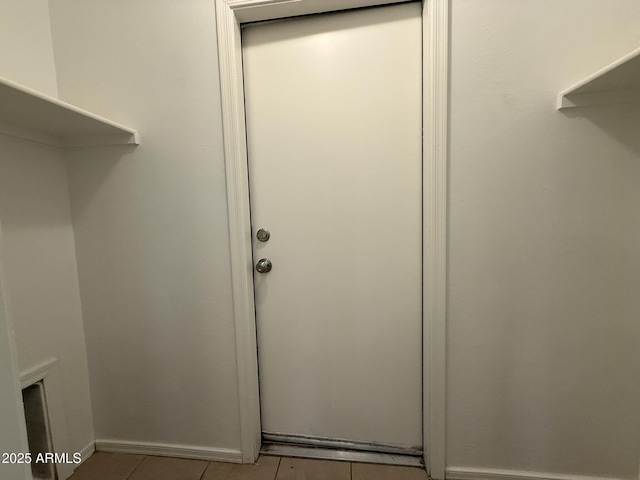 laundry room featuring tile patterned flooring and baseboards