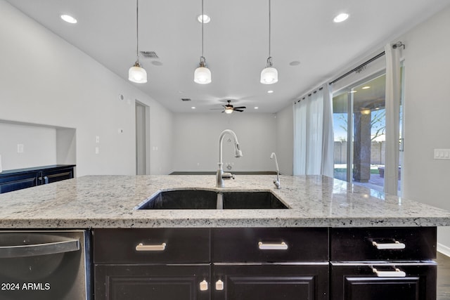 kitchen featuring dishwasher, a kitchen island with sink, sink, hanging light fixtures, and ceiling fan