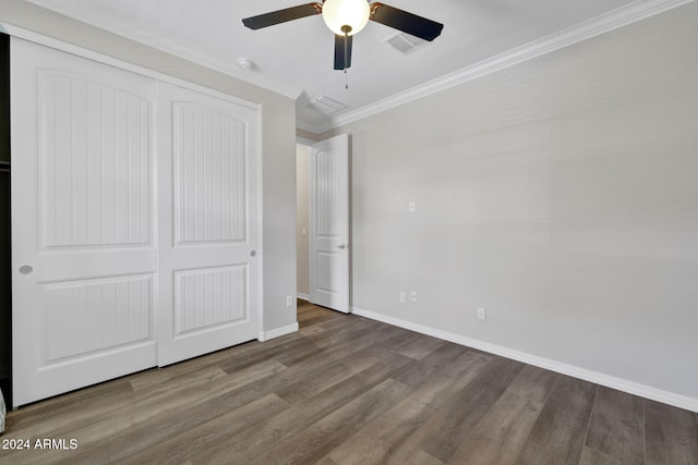 unfurnished bedroom with a closet, hardwood / wood-style floors, and ornamental molding