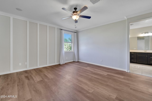 empty room with light hardwood / wood-style flooring, ceiling fan, and crown molding