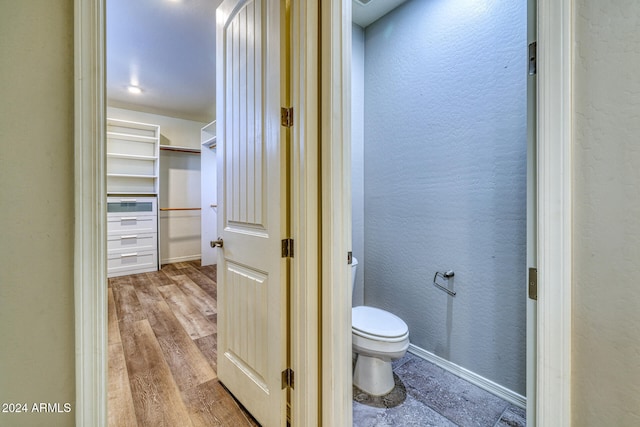 bathroom with toilet and wood-type flooring