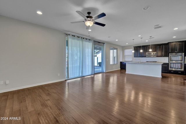 unfurnished living room featuring ceiling fan, dark hardwood / wood-style flooring, and sink