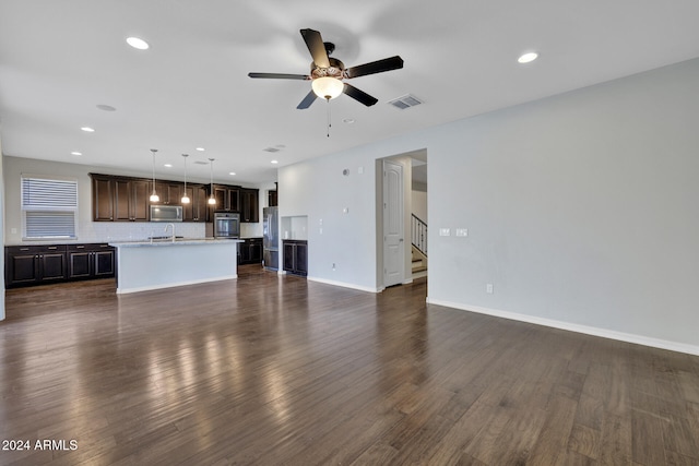 unfurnished living room featuring ceiling fan and dark hardwood / wood-style flooring