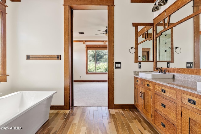 full bathroom with a ceiling fan, wood finished floors, and baseboards