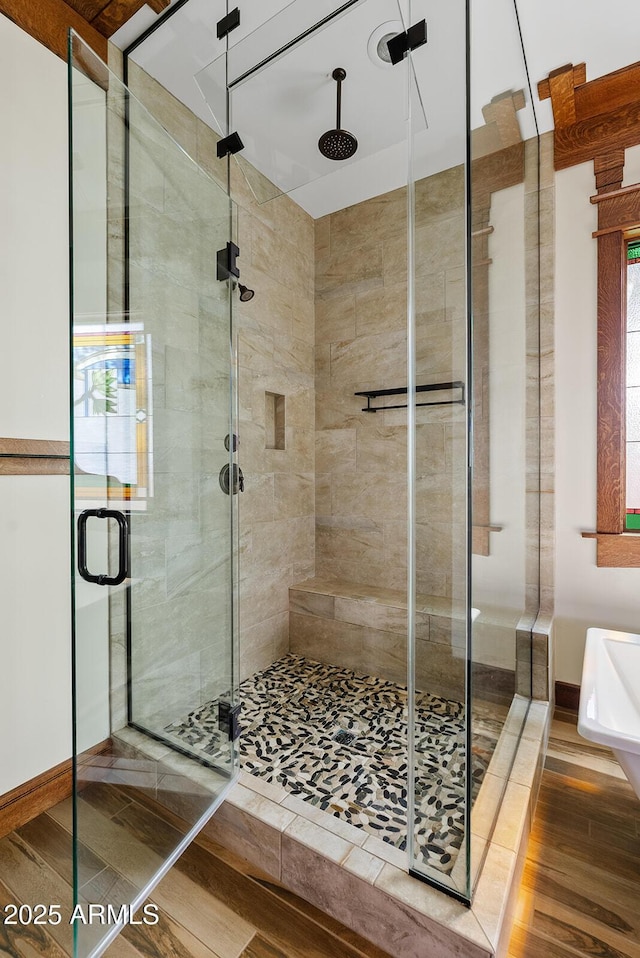 full bathroom featuring a stall shower and wood finished floors