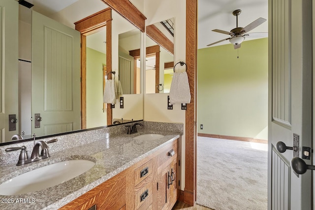 full bathroom with ceiling fan, double vanity, and baseboards