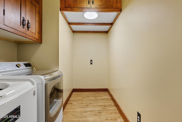 washroom with cabinet space, separate washer and dryer, light wood-style floors, and baseboards