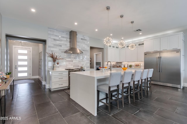 4331 N 19th Pl, Phoenix, AZ 85016 - kitchen featuring glass insert cabinets, high end appliances, tasteful backsplash, wall chimney range hood, and light countertops