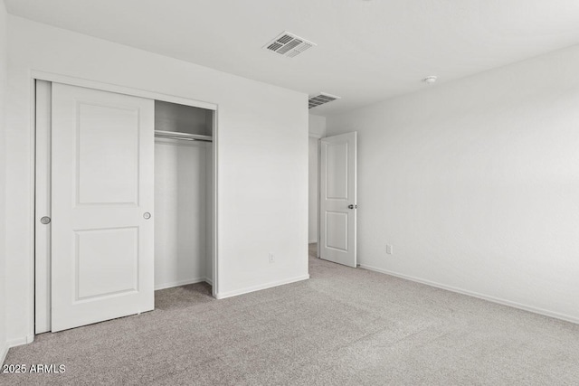 unfurnished bedroom featuring a closet, visible vents, baseboards, and carpet flooring