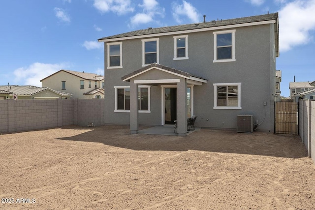 rear view of house featuring a patio area, a fenced backyard, central AC unit, and stucco siding