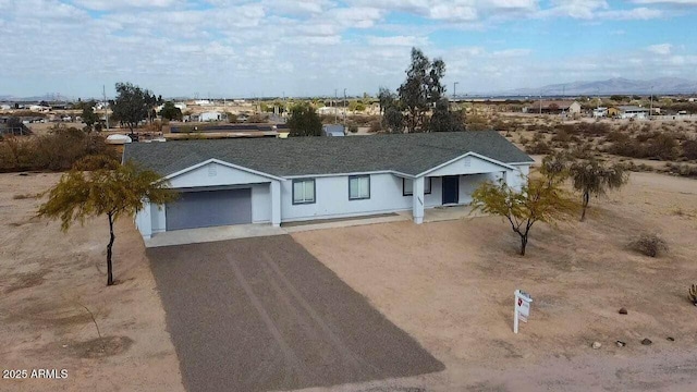 ranch-style home featuring a garage and a mountain view