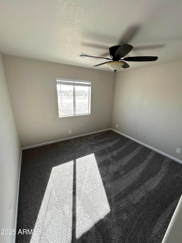 unfurnished room with ceiling fan, dark carpet, and a textured ceiling