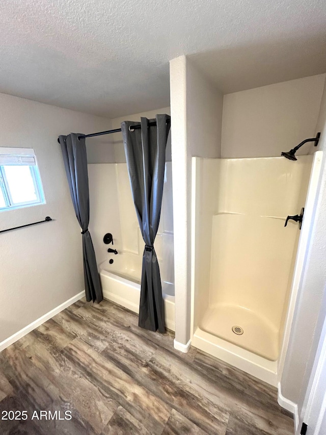 bathroom featuring a textured ceiling, shower / tub combo, and wood-type flooring