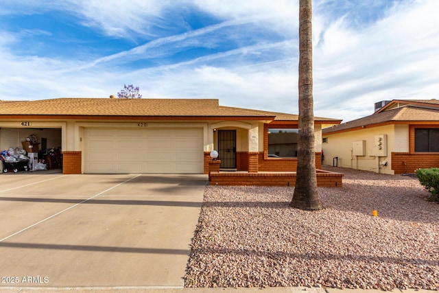 ranch-style home with an attached garage, concrete driveway, and brick siding