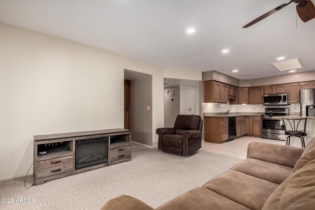 living room with baseboards, a ceiling fan, recessed lighting, and light colored carpet