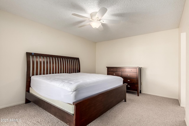 bedroom with baseboards, a ceiling fan, a textured ceiling, and light colored carpet