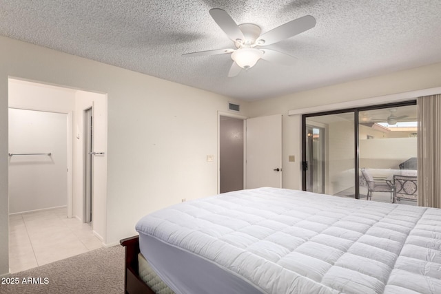 bedroom with a ceiling fan, a textured ceiling, visible vents, and light tile patterned floors