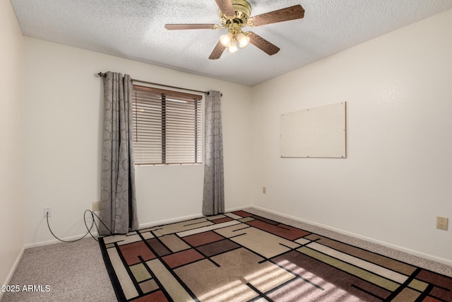 spare room featuring carpet floors, baseboards, a ceiling fan, and a textured ceiling