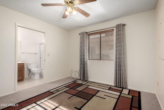 unfurnished bedroom featuring light colored carpet, a textured ceiling, and baseboards
