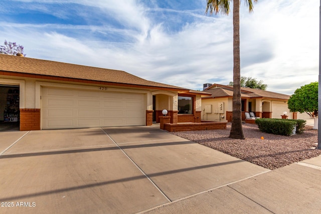 ranch-style home with concrete driveway, brick siding, an attached garage, and a porch