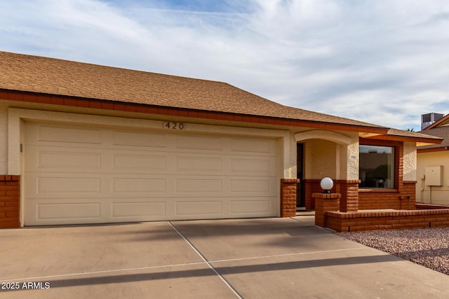 ranch-style house featuring concrete driveway, brick siding, a shingled roof, and a garage