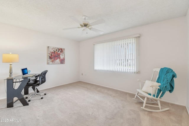 office space featuring ceiling fan, light colored carpet, and a textured ceiling