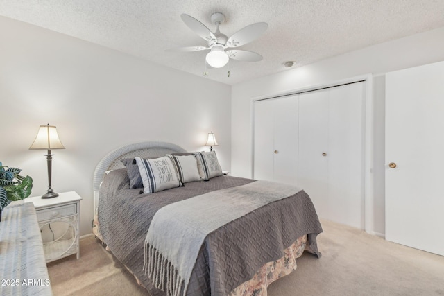 bedroom with light carpet, a textured ceiling, a closet, and ceiling fan