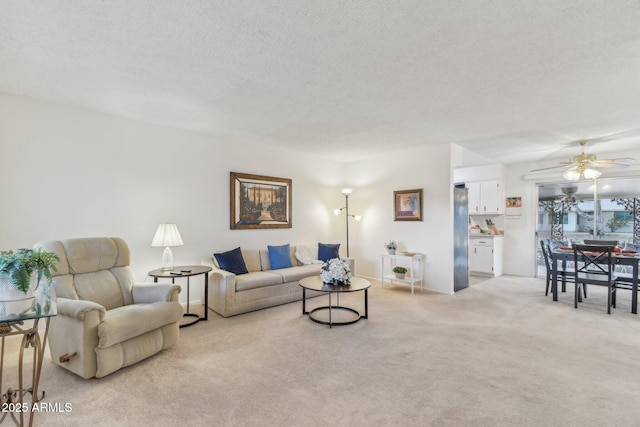 living room featuring light carpet, ceiling fan, and a textured ceiling